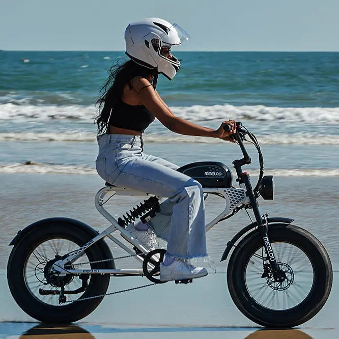 A woman wearing a helmet riding a Meelod DK300PLUS along the coast